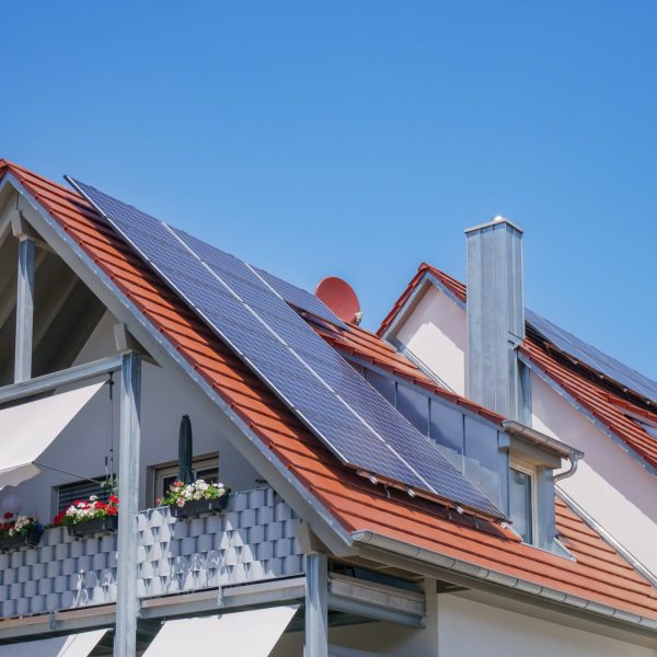 An image of a home with solar energy green plants and sunny blue sky